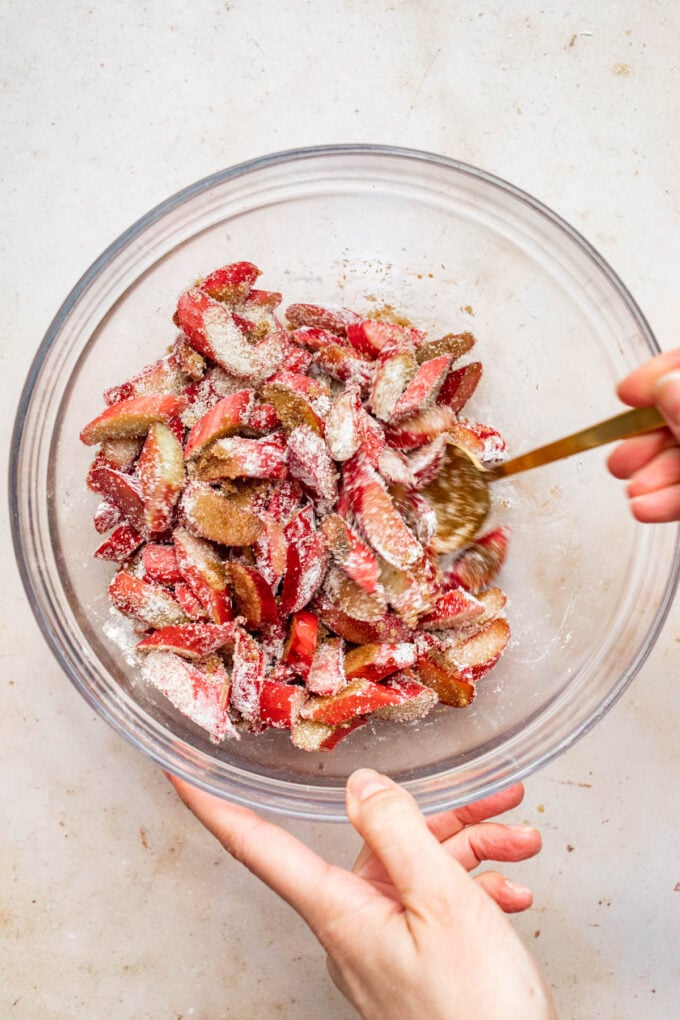 hand mixing rhubarb in bowl